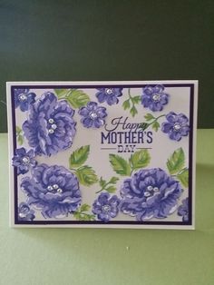 a mother's day card with purple flowers on the front and green leaves on the back