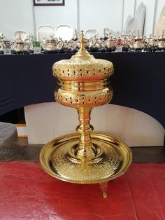 a gold plate on a red table in front of a blue table cloth