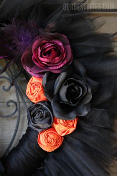 black and orange wreath with flowers on it