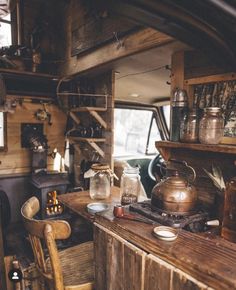 an old fashioned kitchen and dining area in a small cabin with wood flooring, wooden walls