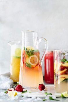 pitchers filled with lemonade, raspberry and limeade next to pitchers of water