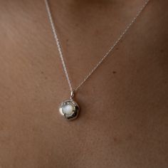 Embrace the gentle healing power of the sea with the soothing energy of Mother of Pearl. Our Keeper Necklace is crafted to hold its essence close to your heart, offering a constant source of comfort and serenity. Nestled delicately within the organically shaped three-pronged Keeper pendant, the Mother of Pearl radiates its tranquil aura. Technically known as "nacre," this crystallized mineral compound forms on the inner shell layer of select mollusks. Saltwater oysters, abalone, and freshwater m Sterling Silver Necklaces With Moon Charm For Meditation, Nature-inspired White Necklaces For Healing, White Nature-inspired Necklaces For Healing, Elegant Round Pendant Charm Necklaces For Healing, Delicate Sterling Silver Keepsake Necklace, Ethereal Sterling Silver Pendant Necklace, Ethereal Pendant Necklace For Gifts, Elegant Round Pendant Charm Necklace For Healing, Ethereal Necklace With Moon Charm For Gifting