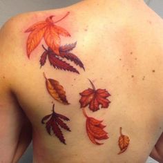 the back of a woman's shoulder with leaves painted on her left arm and chest