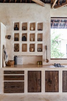 a kitchen with wooden cabinets and shelves on the wall