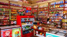 a store filled with lots of different types of food and drink bottles on shelves next to each other