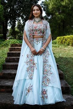 Blue attached cancan lehenga with floral thread and zardosi embroidery. Paired with a zardosi embroidered padded blouse and embroidered cape with scallop edges. - Aza Fashions Fitted Dola Silk Sharara With Floral Embroidery, Dola Silk Floral Embroidery Set For Reception, Bollywood Style Gown With Floral Embroidery In Art Silk, Raw Silk Palazzo Set With Floral Embroidery For Reception, Floral Embroidered Lehenga With Traditional Drape For Reception, Traditional Organza Choli With Floral Embroidery, Multicolor Floral Embroidered Palazzo Set For Wedding, Bollywood Style Art Silk Gown With Floral Embroidery, Raw Silk Sharara With Floral Embroidery For Reception