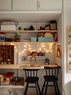 two black chairs sitting in front of a desk with books and toys on top of it