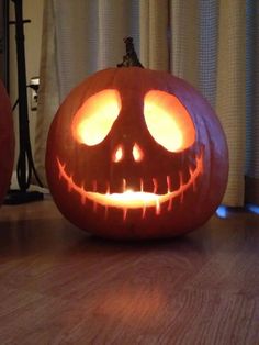 two carved pumpkins sitting on top of a wooden table