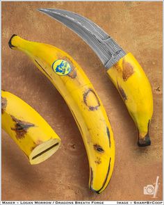 two yellow bananas are next to a knife on a brown surface, with the peels still attached