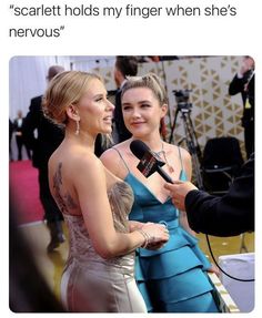 two women talking to each other on the red carpet