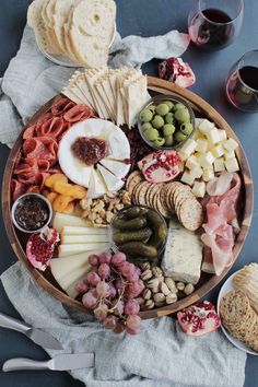 a platter filled with different types of cheeses, meats and crackers