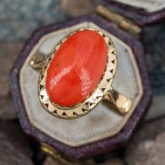 This vibrant vintage 18k yellow gold ring features a bezel set natural oval coral cabochon with a pierced oval bezel border. The ring is currently size 7. Vintage Oval Coral Jewelry, Vintage Coral Oval Jewelry, Elegant Oval Coral Rings, Coral Oval Jewelry For Weddings, Elegant Coral Oval Rings, Antique Oval Cabochon Ring With Bezel Setting, Antique Bezel Set Oval Cabochon Ring, Red Cameo Oval Jewelry, Art Deco Oval Cabochon Rings