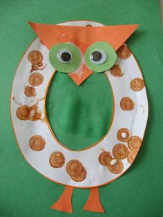 a paper plate with an owl on it's face and some cookies in the shape of a letter o