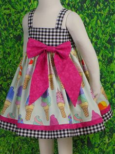 "Girls Soft Serve Ice Cream Cone Dress is perfect for Birthday Party. Toddler Ice Cream dress would be great for all your Summer events. This Unique dress can be a Fancy Party Dress with a Tutu underneath and Cute Bow. Perfect for School with it's Strap Style that is Great for Layering. This cute style Dress features a Lined Bodice and Full Twirl Skirt. Pull Over the Head style is Simple for Dressing and Comfy enough for a day of play. The Elastic Back is a Grow with me Style. The Oversized Bow Playful Multicolor Dress For Picnic, Playful Gingham Dress For Playtime, Playful Gingham Dress With Ruffles, Playful Sleeveless Gingham Dress, Sweet Gingham Cotton Dress, Playful White Dress For Picnic, Sweet Gingham Dress For Spring, Sweet Spring Gingham Dress, Cute Gingham Dresses For Garden Party