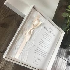 a wedding card in a white box with a bow tie on the inside of it