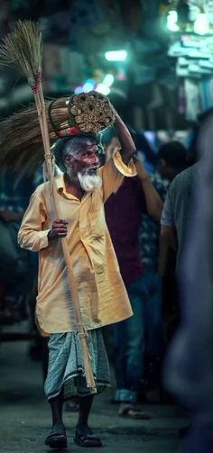 a man walking down a street holding a broom