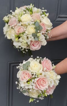 two bridal bouquets with white and pink flowers are held by the bride's hands