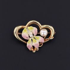 Iris, the Greek goddess of the rainbow, was said to bridge heaven and earth. This antique 14k gold brooch (circa 1900-1915) features an iris flower adorned in iridescent enamel with two post set pearl accents.  The brooch measures 0.8 inches from top to bottom by 1 inch wide, and it is in excellent condition. We have many other fantastic offerings of period fine and costume jewelry posted on our Etsy store, so please consider browsing our other items. We send all items in individually packaged g Art Nouveau Brooch Jewelry For Anniversary, Art Nouveau Brooch For Anniversary, Collectible Gold Flower Enamel Pin, Art Nouveau Gold Brooches As Gift, Art Nouveau Yellow Gold Brooches Gift, Art Nouveau Enamel Brooch Jewelry, Victorian Gold Flower Brooch, Art Nouveau Yellow Gold Brooch, Gold Enamel Art Nouveau Brooches