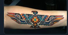 an eagle tattoo on the arm with colorful colors and lines in it's wings