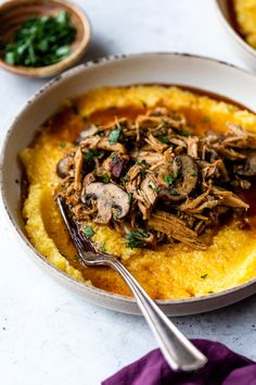 a bowl filled with mashed potatoes topped with meat