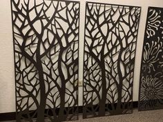 three metal panels with trees on them in the shape of leaves and branches, one is cut