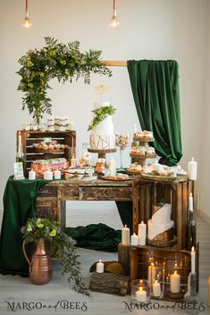 a table topped with lots of food next to a green curtain and candles on top of it