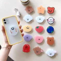 a person holding a cell phone case with many different shaped buttons on the back of it