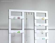 a white jewelry rack with earrings hanging from it