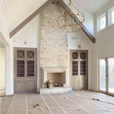 an empty living room with a fireplace in the middle