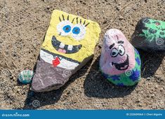 two rocks painted to look like spongebob characters on the ground with their faces drawn