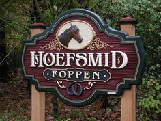 a sign that says hoefsmid toppen with a horse head on it