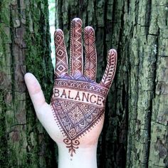 a person's hand with the word balance painted on it in front of some trees