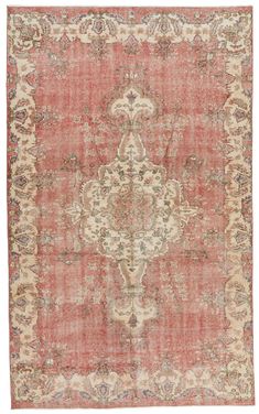 an antique rug with red and beige colors