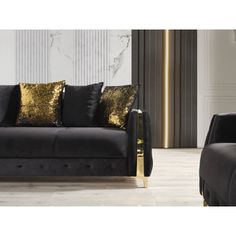 a black couch with gold pillows in a room