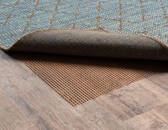 a blue and brown area rug on the floor with wood grained floors in the background