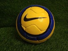 a yellow and blue nike soccer ball on the grass