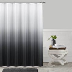 a shower curtain with black and white ombrettas on the side in a bathroom