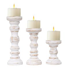 three white candles are sitting next to each other