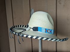 The Renegade Gus Palm Hat has a 4" brim and 5 1/2" crown. Super comfortable with a sweat band on the inside. Hand laced in black leather lace. Beautiful blue beaded hatband is secured on the hat and the back of the band has a deer antler bead. Accented with a Concho and Guinea feathers. Note: Hats are made to order. Please allow up to 4 weeks for your hat to ship Festival Adjustable Hats With Bead Caps, Adjustable Festival Hats With Bead Caps, Adjustable Bead Caps Hats For Festivals, Adjustable Bead Caps Festival Hats, Adjustable Brimmed Hats With Bead Caps, Adjustable Flat Crown Hats For Kentucky Derby, Adjustable High Crown Felt Hat In Country Style, Western Costume Hat With Flat Crown, Custom Costume Hat With High Crown And Adjustable Fit