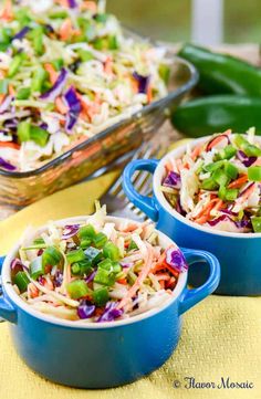 two blue dishes filled with coleslaw slaw on top of a yellow cloth