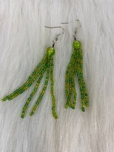 Hi Everyone, Pretty long green earrings just for St Patrick's fashion statement. Handmade Earrings, Green Long Sm Beads Tassels, Dangle Drop Earrings. Handmade fashion jewelry, perfect gifts for her and for your special friends. Can be for everyday look fashion accessories for every women. The length is about 3.5 inches from top to bottom.  Thank you for looking at my pretty earrings jewelry shop. Green Beaded Fringe Earrings For Party, Green Fringe Tassel Earrings For Party, Green Beaded Fringe Jewelry For Party, Green Fringe Beaded Drop Earrings, Handmade Green Chandelier Earrings For Party, Elegant Green Beaded Earrings With Tassels, Elegant Green Beaded Fringe Tassel Earrings, Elegant Green Earrings With Beaded Fringe, Green Dangle Tassel Earrings With Fringe