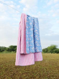 clothes hanging out to dry on a line in a field with blue sky and clouds