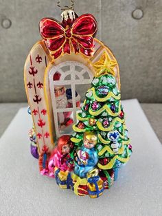 a christmas ornament with a small tree in front of it