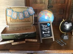 there is a suitcase, globe and other items on the table in front of it