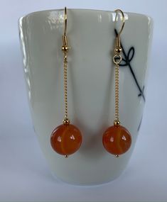 Hand made with love Earring length: 5 cm 10 mm carnelian beads  Gold plated chain and hoops To see all jewelry, check the list here https://www.etsy.com/ca/shop/EmilyGemJewelry Orange Gemstone Dangle Jewelry, Handmade Amber Agate Earrings, Carnelian Gemstone Dangle Earrings, Carnelian Dangle Earrings With Natural Stones, Carnelian Natural Stones Dangle Earrings, Red Agate Earrings For Gift, Red Agate Earrings As Gift, Hypoallergenic Agate Round Beads Jewelry, Gemstone Bead Drop Earrings For Gifts