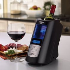 a glass of wine sitting next to an appliance on top of a table