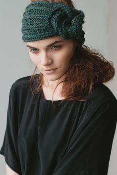 a woman wearing a green knitted headband with a knot at the top and side