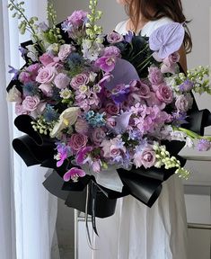 a woman holding a large bouquet of flowers