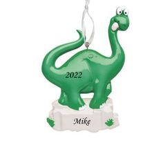 a green ornament shaped like a dinosaur with the name mike hanging from it's neck