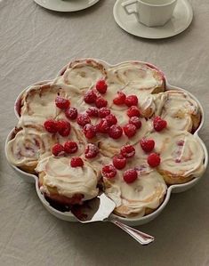 a white plate topped with cupcakes covered in icing and raspberries